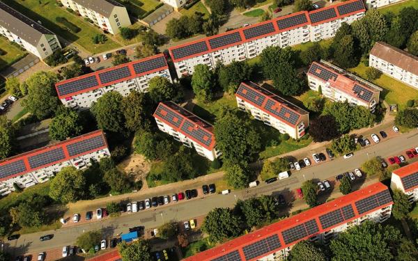 Wohnsiedlung mit hohem Baum- und Grünflächenbestand und ausgedehnten Solaranlagen auf den Dächern. 